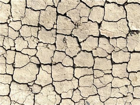 Desert Texture Dry Cracked Earth And Sand Deep Cracks Pierce The Soil