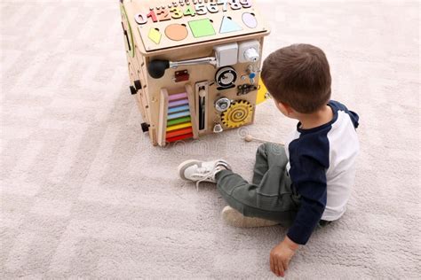 Little Boy Playing With Busy Board House On Floor Stock Image Image