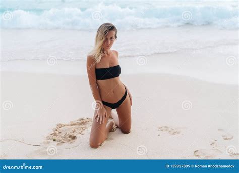 Tanned Model In Black Swimwear Posing On White Sandy Beach Stock Image