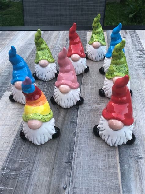 Seven Garden Gnomes Sitting On Top Of A Wooden Table