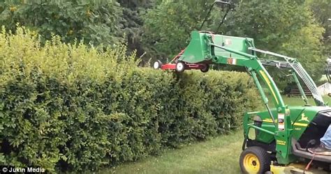 Canada Dad Trims Hedges With Lawnmower Strapped To Backhoe