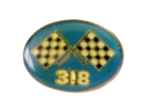 A Blue And Yellow Pin With Two Crossed Checkered Flags On The Back Of It