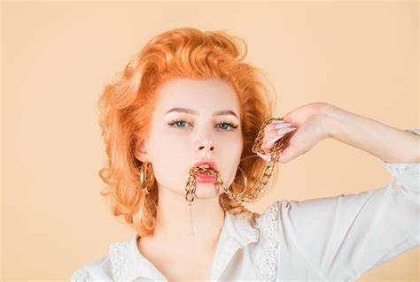 Premium Photo Redhead Woman Close Up Portrait With Golden Chain In Mouth