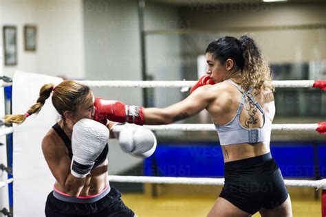 Female Boxer Hitting Her Opponent While Sparring In The Ring Of A