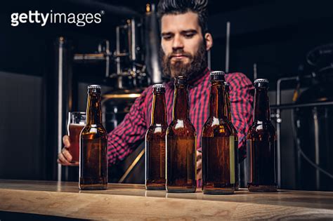 Photo With Craft Beer Bottles On The Foreground And Bearded Male