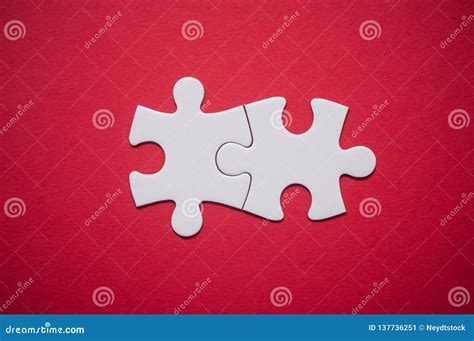 Two Connected Jigsaw Puzzle Pieces On Red Background The Concept Of