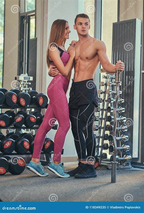 Young Sporty Couple Naked Muscular Guy And Slim Girl Wearing Sportswear Posing While Cuddling