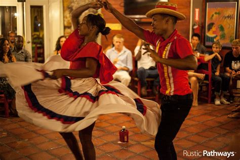 Two People In Red Shirts And White Skirts Dancing With Other People