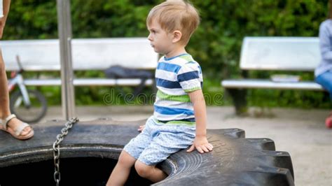 Portrait Of Adorable 3 Years Old Little Boy Sitting On The Playground