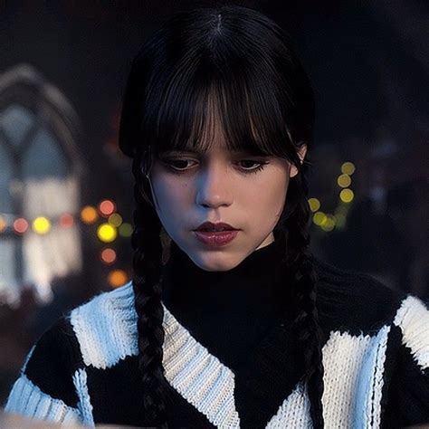 A Woman With Long Black Hair Wearing A Striped Sweater Looking At Her