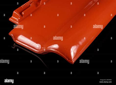 Single New Shinny Red Roof Tile Isolated On The Black Background Stock