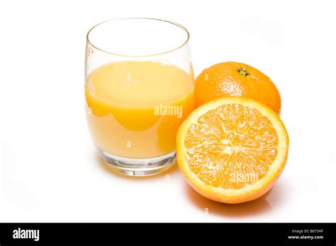 Glass Of Freshly Squeezed Orange Juice With A Halved Orange Isolated