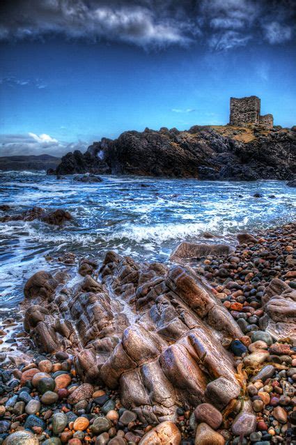 An Old Castle Sits On Top Of A Rocky Shore
