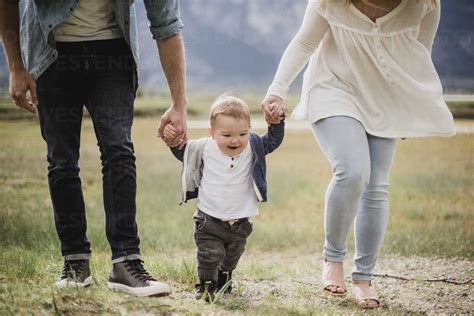 Parents Walking With Baby Son In Field Stock Photo