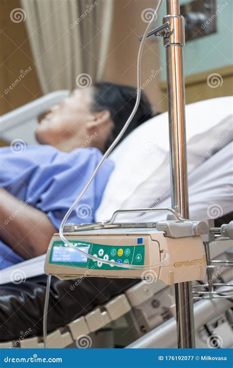 The Patient Is Lying On A Bed In A Hospital With An Automatic Infusion