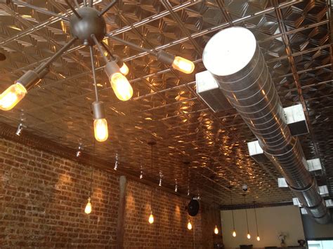 Tin Ceiling With Brick Wall Exposed Duct Work Bronze Wall Sconce