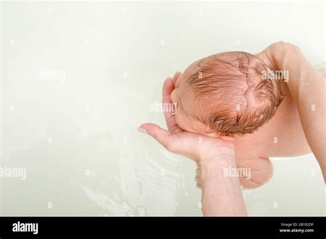 Madre Bañándose Bebé Recién Nacido Sosteniendo La Cabeza Del Niño Con