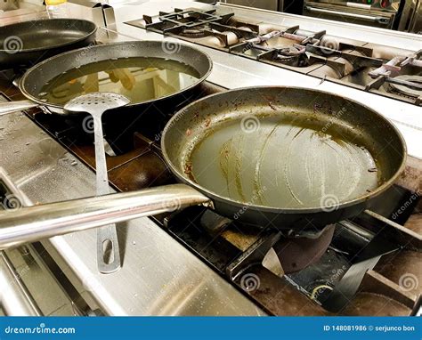 Frying Pans With Oil And Cooking In The Kitchen Of A Restaurant Stock