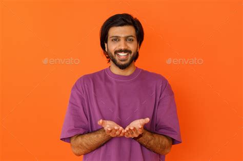 Happy Smiling Young Indian Man Holding Something In His Palms Stock