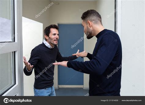 Two Young Men Standing Door Entrance Quarreling Each Other Stock Photo