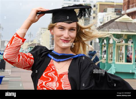 brighton uk 30th july 2019 lois green hangs on to her mortar board after graduating from the