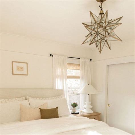 A White Bedroom With A Star Light Hanging From The Ceiling