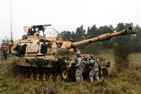 Us Soldiers Check The Perimeter Of An M109a6 Paladin Howitzer During