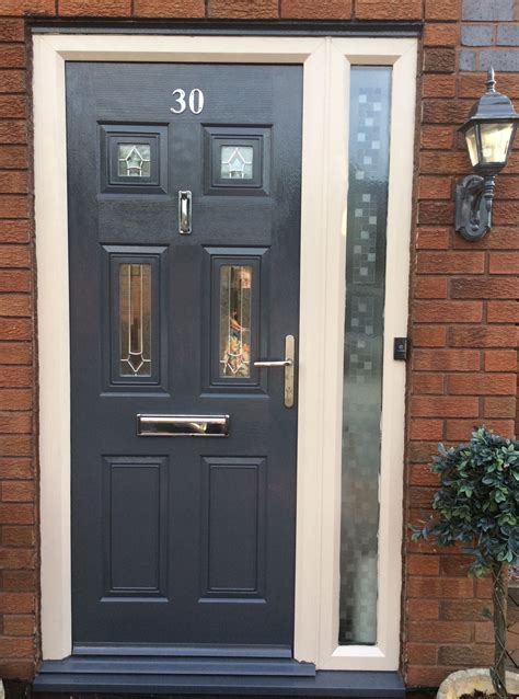 A Black Front Door With Two Sidelights On Brick Wall Next To Potted Plant
