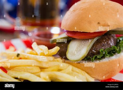 Close Up Of Burger And French Fries On Wooden Table With 4th July Theme