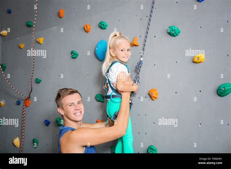 Instructor Helping Little Girl Climb Wall In Gym Stock Photo Alamy