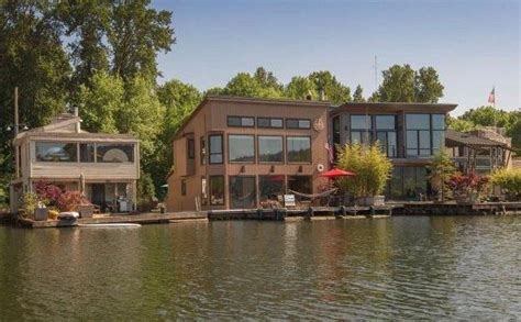 Two Houses On The Water With Trees In The Background