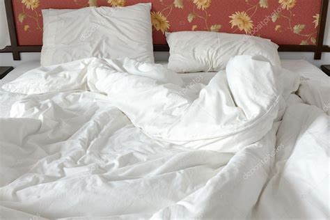 Unmade Untidy Bed With A White Crumpled Blanket And Two Messy Pillows