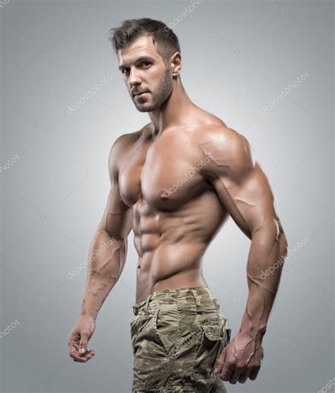 Muscular Athlete Bodybuilder Man On A Gray Background Stock Photo By Bondarchik