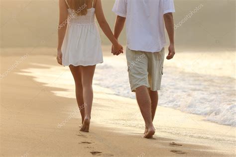 Couple Taking A Walk Holding Hands On The Beach Stock Photo By