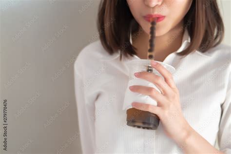 happy smiling asian woman drinking iced bubble milk tea aka boba tea pearl milk tea tapioca