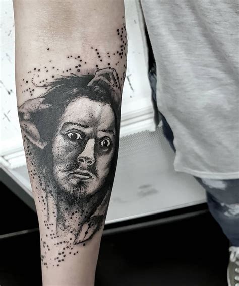 A Mans Leg With A Black And White Tattoo On It That Has An Image Of A Dog