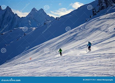 Alpine Skiers Embrace The Stunning Snowy Backdrop Of The Mountain Range