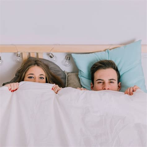 Free Photo Couple Under Blanket Looking At Camera