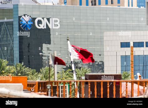 Qatar National Bank Qnb Office In Doha With Qatari Flags Stock Photo