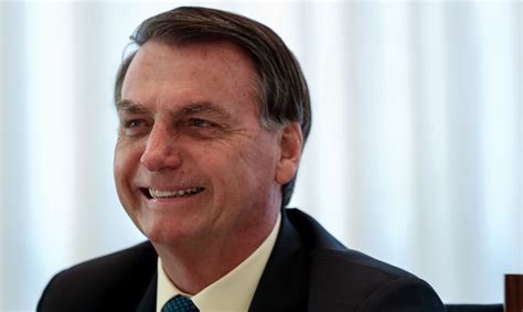 O cão que fuma Bolsonaro sanciona lei de auxílio financeiro para o