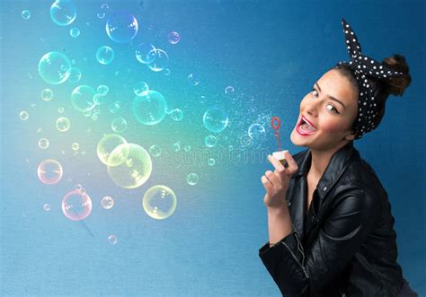 Pretty Lady Blowing Colorful Bubbles On Blue Background Stock Photo