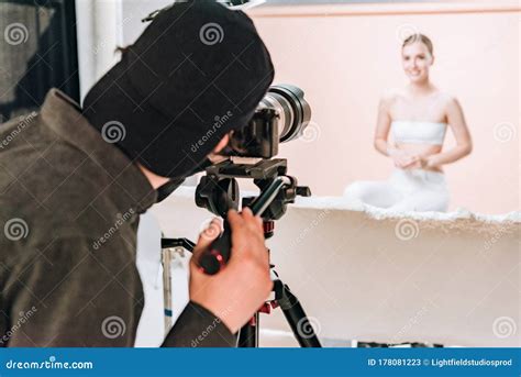 Focus Of Cameraman Shooting Smiling Model In Photo Studio Stock Image