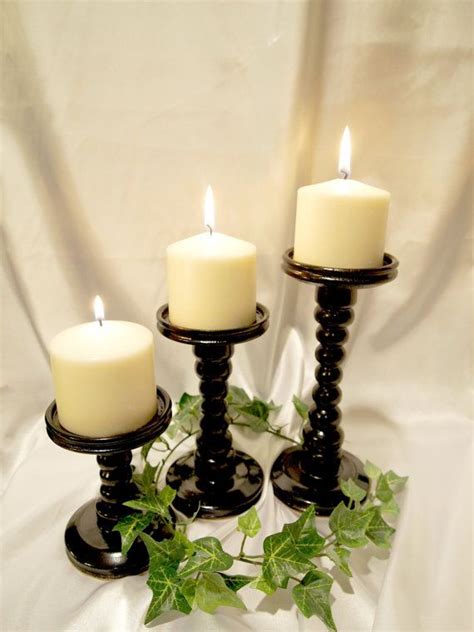 Three Candles Sitting On Top Of Each Other In Front Of A White