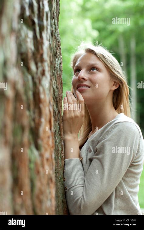 Woman Leaning Against Tree Looking Up Stock Photo Alamy
