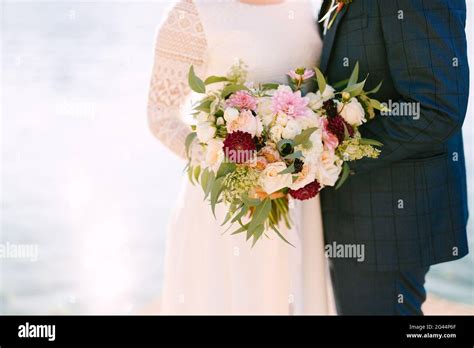 Bride And Groom Holding A Beautiful Bouquet Of Flowers Stock Photo Alamy