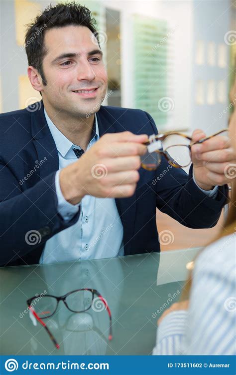 Optician Passing Eyeglasses To Client Stock Photo - Image of optometrist, eyecare: 173511602
