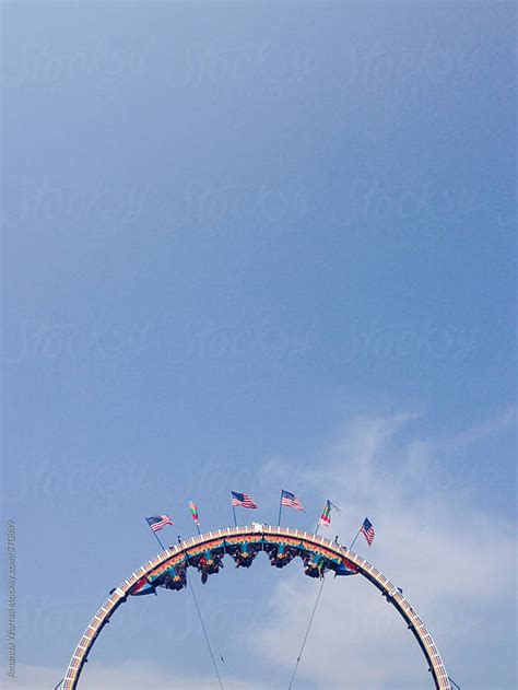 Circular Carnival Ride With American Flags Against A Blue Sky By Amanda