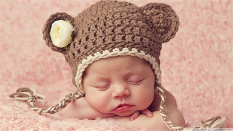 Cute Beautiful Newborn Baby Is Sleeping On Hands Wearing Brown Woolen