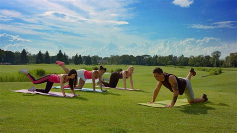 Outdoor fitness training. Group of people doing legs exercise in sunny ...