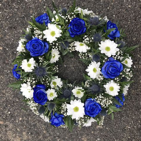 A White And Blue Funeral Floral Wreath Tribute Of Roses Thistle